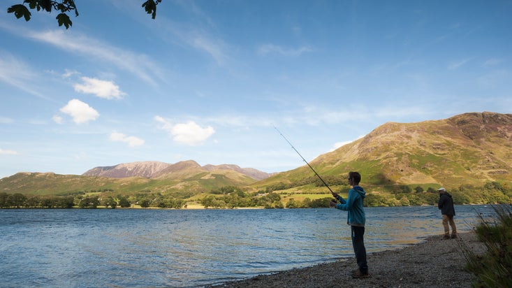 Person fishing on shingle shores of Buttermere